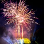 Spectacular fireworks illuminating the night sky at a festival celebration.